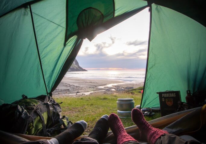 two people in a tent looking out to sea